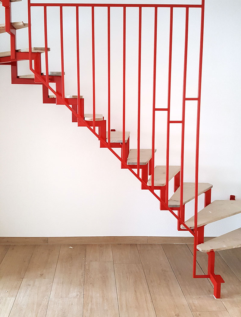 Frisch gestrichennes rotes Treppengeländer aus Metall